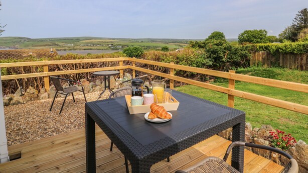 Une terrasse avec une table préparée pour le petit-déjeuner, offrant une vue sur un paysage magnifique.