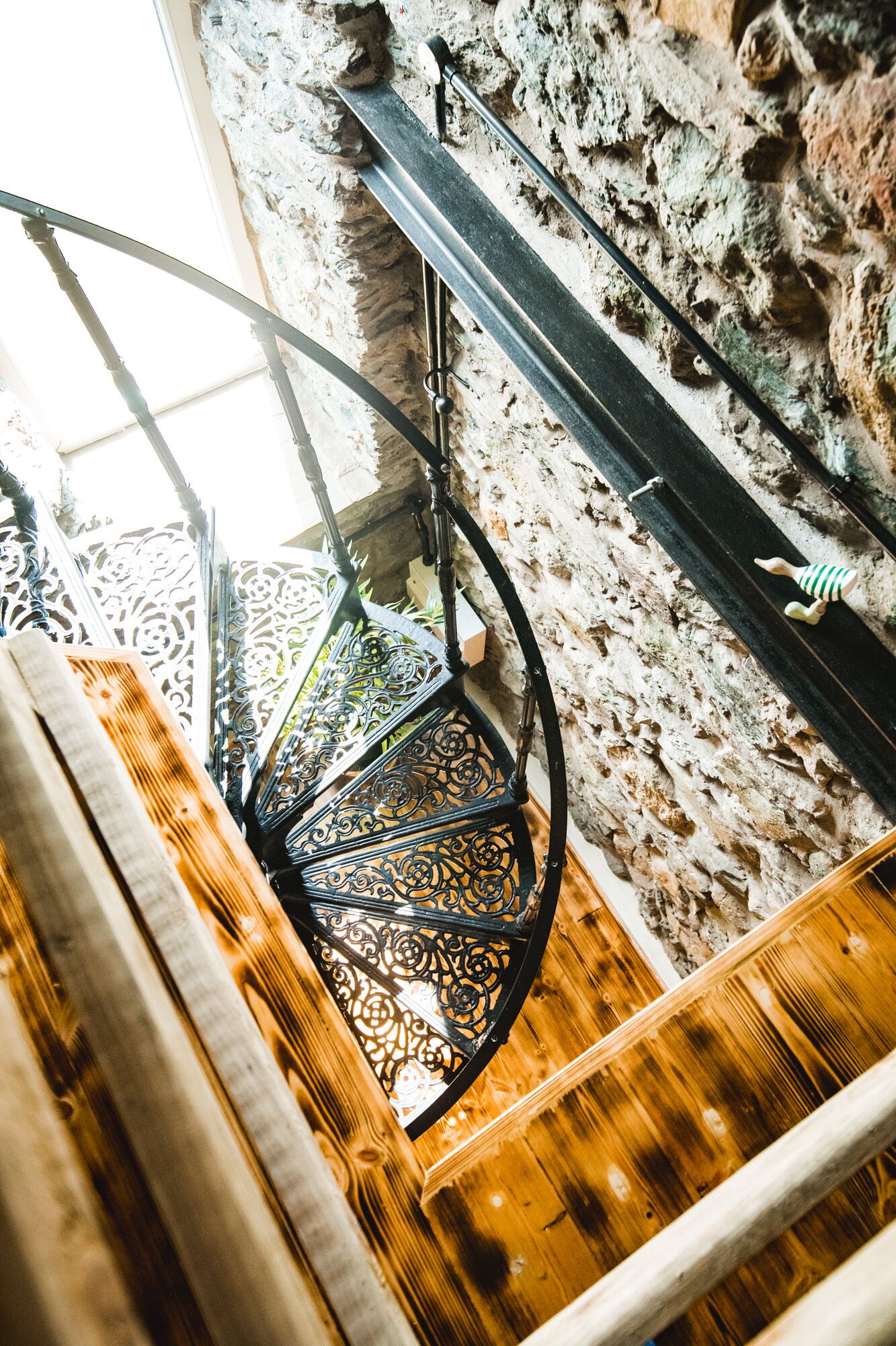 Eine Wendeltreppe mit aufwendig gestalteten Metallgeländern und einem Holzboden.