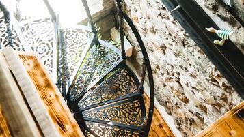 Eine Wendeltreppe mit aufwendig gestalteten Metallgeländern und einem Holzboden.