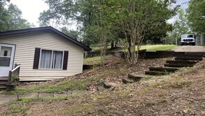 A small, single-story house with a front porch and a garage. - Lake Wateree cottage (Ridgeway)