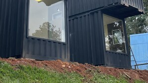 Een modern gebouw met modulaire elementen, grote ramen en een metalen structuur.