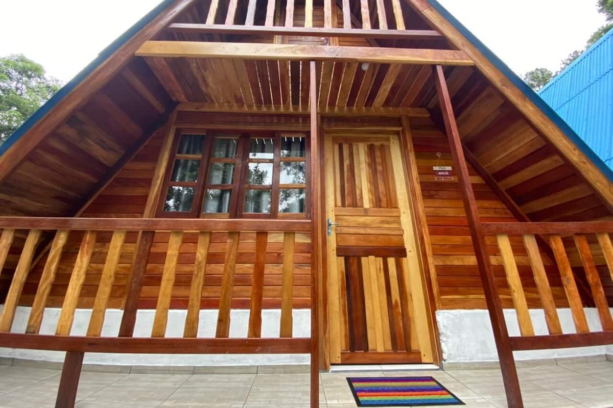 Eine Holzhütte mit geneigtem Dach, einer Haustür und Fenstern.
