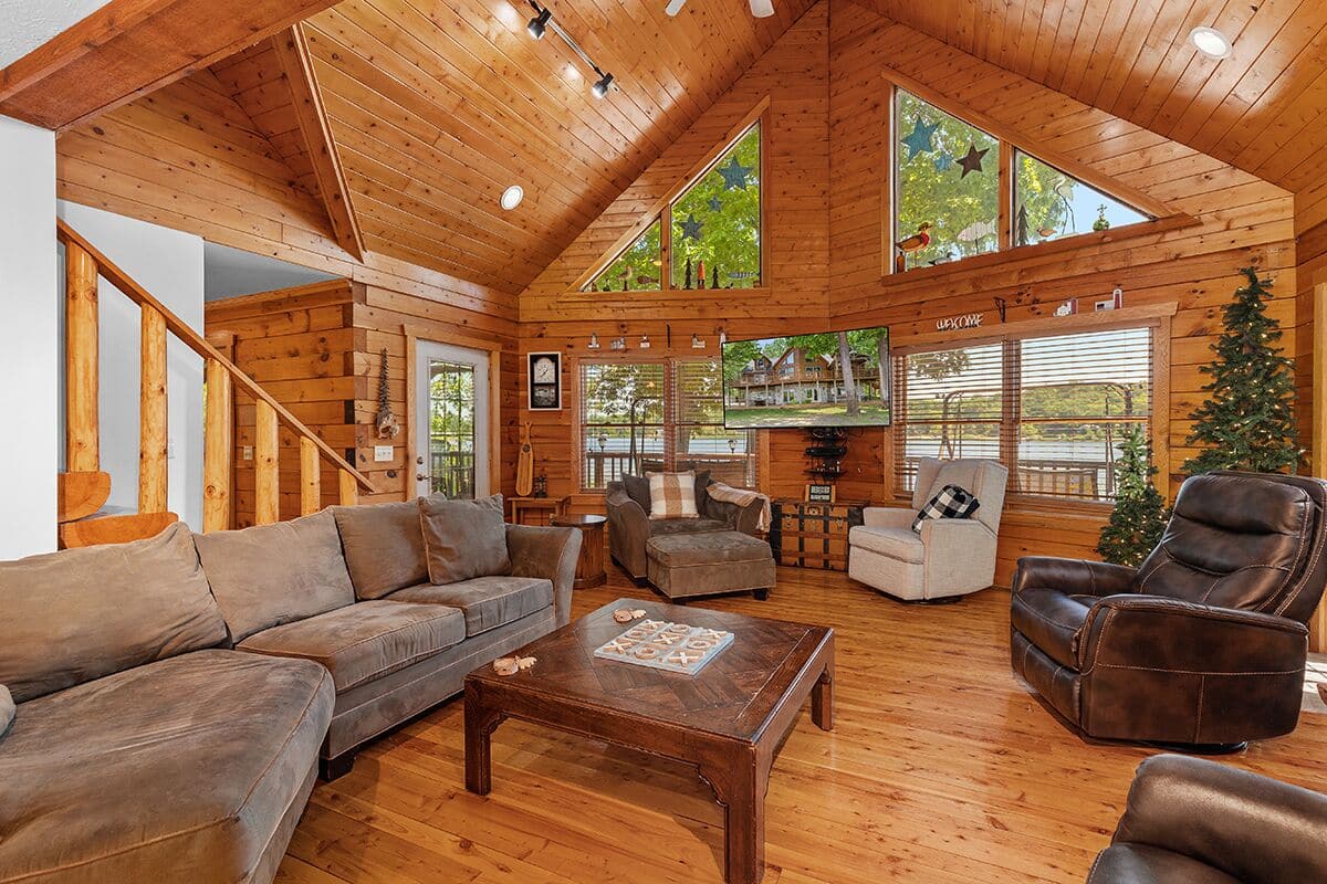L’intérieur de cette vaste cabane en rondins est doté d’un plafond en bois, d’une grande fenêtre donnant sur un paysage magnifique et d’un coin salon confortable agrémenté d’une cheminée.
