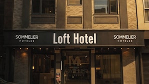 A SOMMELIER hotel building with a modern facade, large windows, and a prominent entrance. - LOFT Hotel by Sommelier Hoteles (Santiago)
