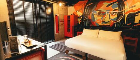 Una habitación de hotel con una cama, un escritorio y un cuadro grande en la pared.