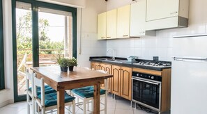 Une cuisine avec des armoires en bois, une cuisinière à gaz et un four encastré.