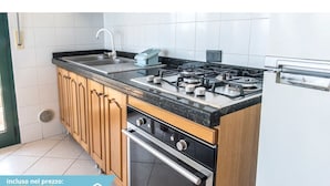 Una cucina con fornelli a gas, forno e lavello.