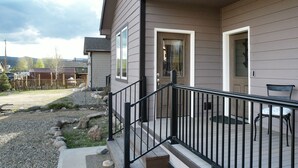 En bostadsbyggnad med en inglasad veranda, en liten uteplats och en grusuppfart.