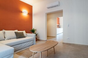 A modern living room with a sofa, a coffee table, and a potted plant.