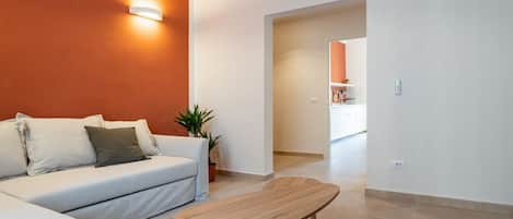Una sala de estar moderna con un sofá, una mesa de centro y una planta en maceta.