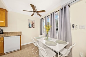 A dining area with a white table, chairs, and a ceiling fan. - Cozy & Serene ~ 12 mins to Downtown LA (Alhambra)