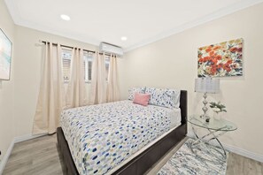 A bedroom with a bed, a glass table with a lamp, and a painting on the wall. - Cozy & Serene ~ 12 mins to Downtown LA (Alhambra)