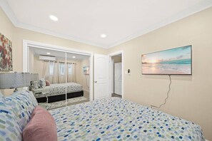 A bedroom with a bed, a bedside table, a lamp, a painting, and a door leading to another room. - Cozy & Serene ~ 12 mins to Downtown LA (Alhambra)