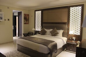 A hotel room with a large bed, bedside tables, a desk, and a chair. - TIO SEA Resort AL Khor (Al Khor)