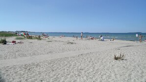 En strand där folk solar och badar.