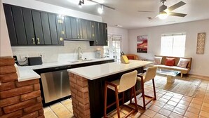 A kitchen with dark cabinets, a stainless steel dishwasher, and a tiled floor. - Quaint 1-bedroom Unit  w/ Hottub in Uptown Sedona (Sedona)