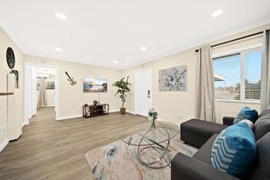 Ein modernes Wohnzimmer mit einer Couch, einem Couchtisch und Kunstwerken an den Wänden.