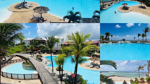 Een resort met een groot zwembad, een strandgedeelte en uitzicht op de oceaan.