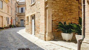 A narrow cobblestone street flanked by historic buildings with brick facades and traditional shutters. - [Historic Center] A/C e WiFi in the Heart of Le Marche region (Lapedona)