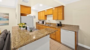 A modern kitchen with granite countertops, wooden cabinets, a built-in dishwasher, and a microwave. - Cozy n Serene 12mins to Downtown LA (Alhambra)