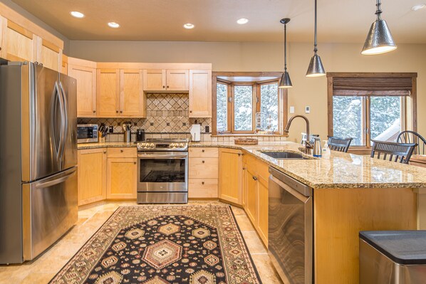 Enjoy cooking in this well-equipped kitchen with a large island, stainless steel appliances, and a dishwasher.