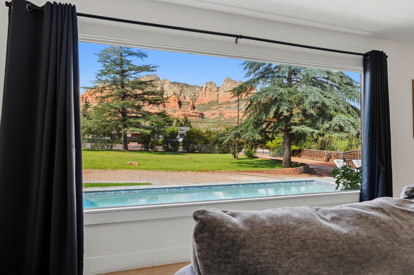 Ein Zimmer mit großem Fenster und Blick auf einen Pool und eine natürliche Landschaft.
