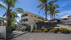 En moderne bygning med et skilt der viser "CALLESTA PLAZA" og en portindgang.