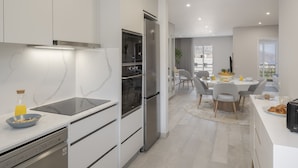Een moderne keuken met een inbouwoven, een koelkast en een vaatwasser.