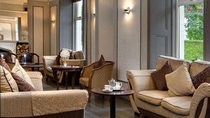 A cozy lounge area with a sofa, armchairs, and a small table with a teapot and cups. - Dryfesdale Hotel, Bw Signature Collection (Lockerbie)