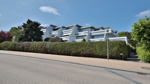 A modern building with a unique architectural design, featuring multiple levels and balconies.