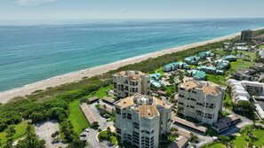 Un hotel costero con varias construcciones, una playa y una vista despejada del océano.
