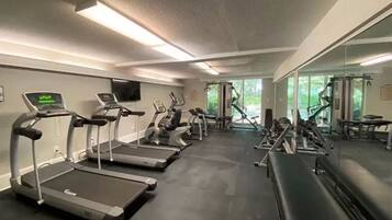 A gym with treadmills, elliptical machines, and weight equipment.
