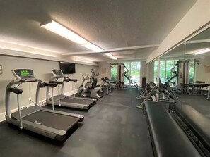 A gym with treadmills, elliptical machines, and weight equipment.