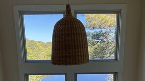 A room with a large window overlooking a body of water and trees. - Private Beach on Pond, Linens Included, Kayak & Canoe. All Rooms w/ Pond Views! (Chatham)