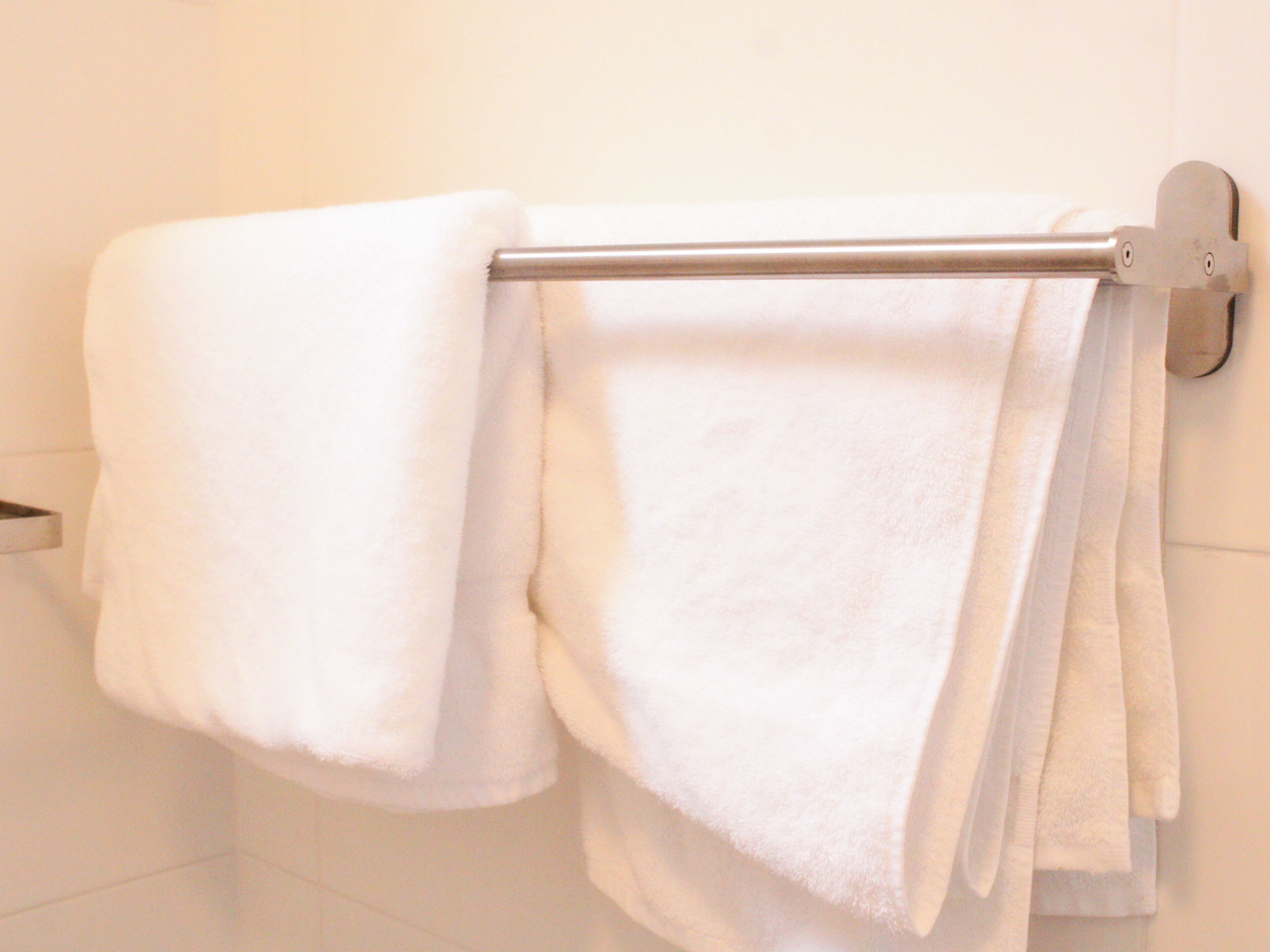 A bathroom with a white towel rack holding two towels.