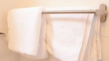 A bathroom with a white towel rack holding two towels.