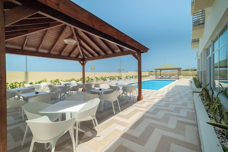 Una piscina al aire libre, sillones reclinables de piscina