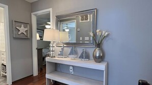 A hallway with a white console table, a mirror, a starfish decoration, and a gray rug. - Beautiful Townhome located near the beach in Beach Haven. (Beach Haven)