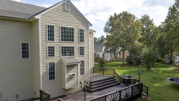 A two-story house with a front deck, a small porch, and a backyard with a trampoline and a grill. - Private bedroom and bath!  (Midlothian)