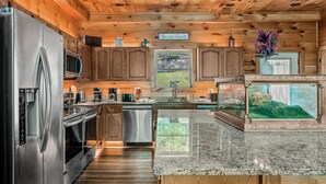 Eine moderne Küche mit Holzschränken, Edelstahlgeräten und einer Arbeitsplatte aus Granit.