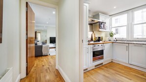 Una cocina moderna con gabinetes blancos, un microondas y una estufa.