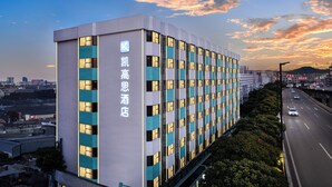 A modern hotel building with a prominent sign, multiple floors, and a well-lit facade. - K-house Hotel (Guangzhou)