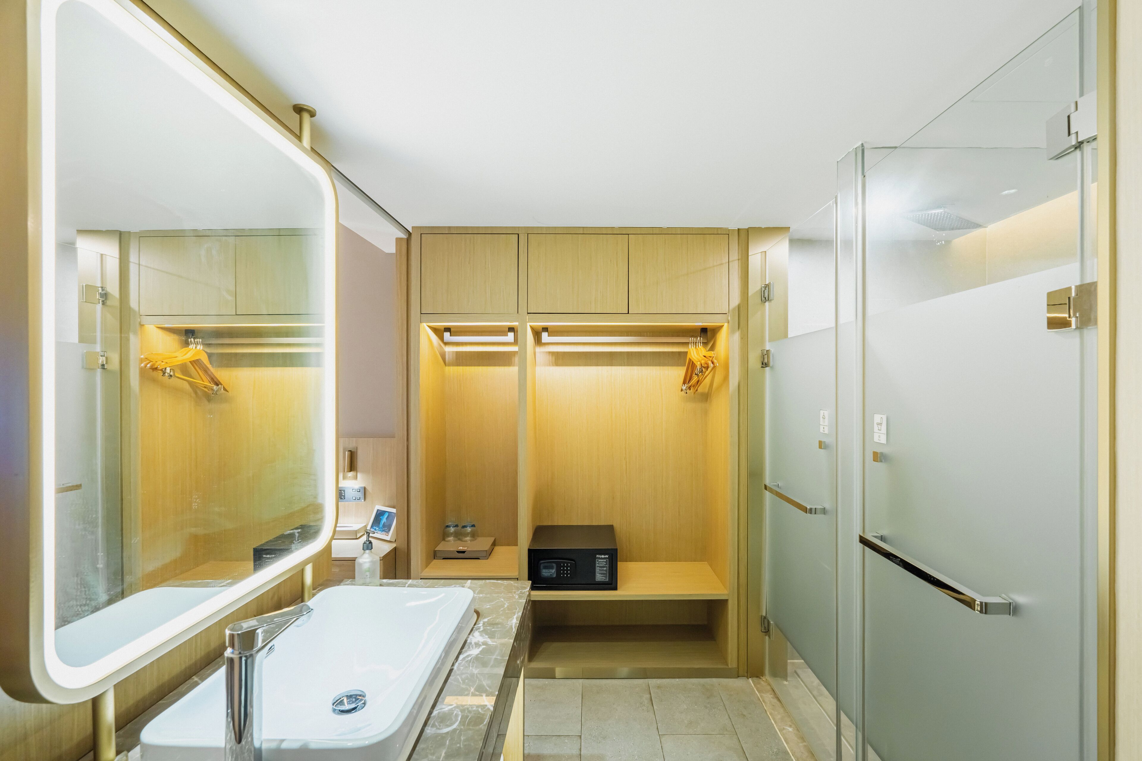 A modern bathroom with a large mirror, a sink, a shower, and a built-in heater.