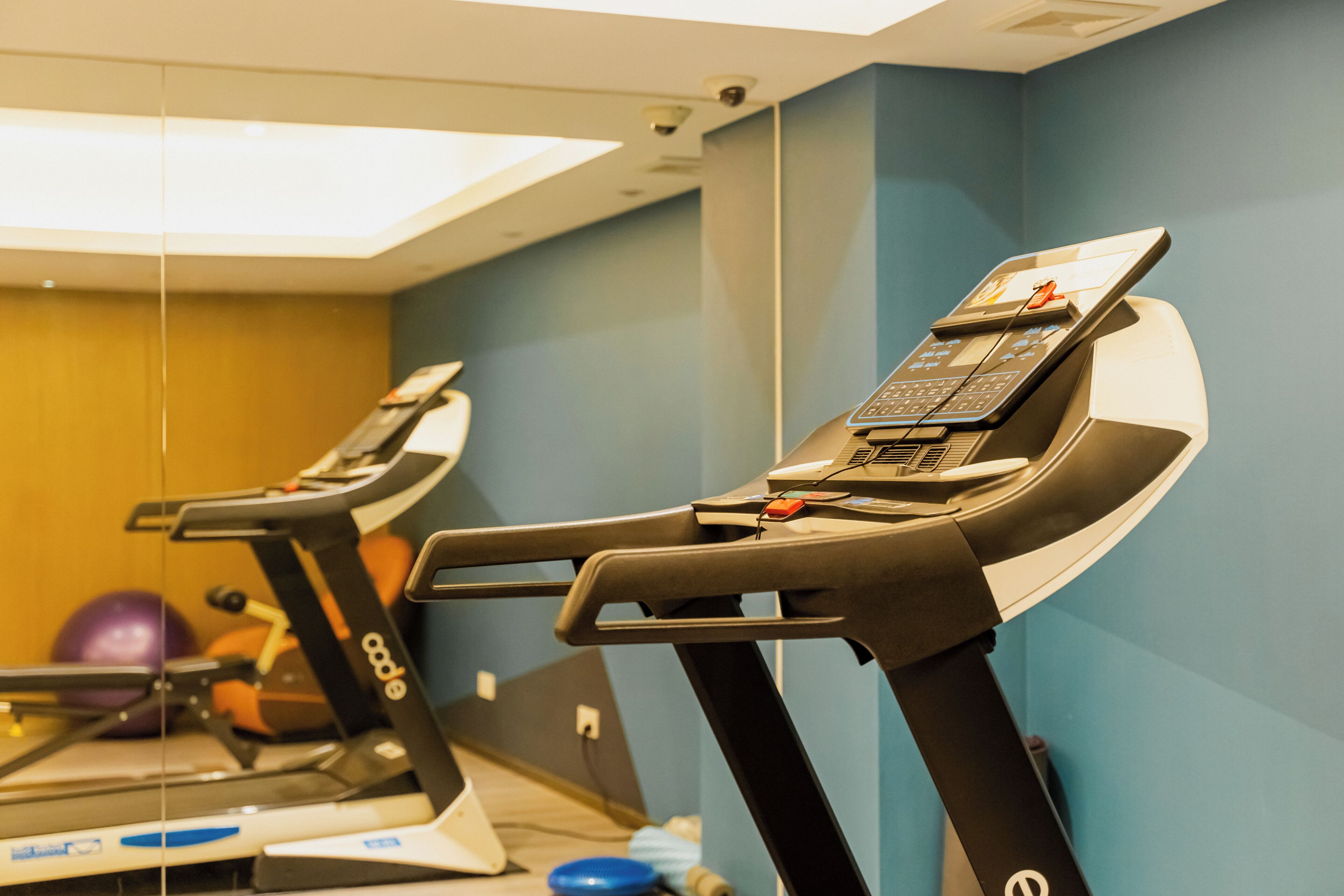 Un gimnasio con cintas de correr y equipo de ejercicio.