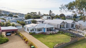 A modern house with a large deck, a covered carport, and a well-maintained lawn. - Mandalay on Pipeclay - 3 Bedroom House - Free Parking - Free WIFI (Cremorne)