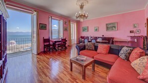 Un salon spacieux avec un grand canapé, un coin repas et une vue sur la mer.
