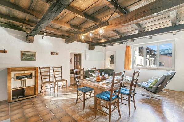 A dining area with wooden chairs, a table, and a vintage radio.