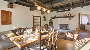 Un coin repas rustique avec une table en bois dressée pour le repas, entourée de chaises.