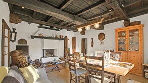 Une salle à manger rustique avec une table en bois, des chaises et un buffet.