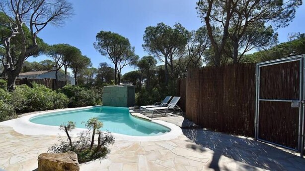 A backyard with a swimming pool, lounge chairs, and a wooden fence. - House Palmito 2, Chiclana de la Frontera (Chiclana de la Frontera)